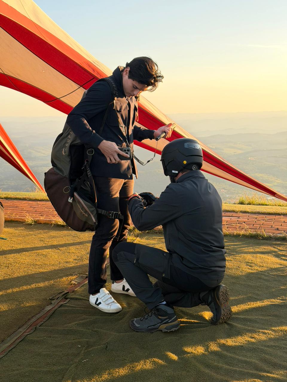 Instrutor preparando voo duplo de parapente com segurança